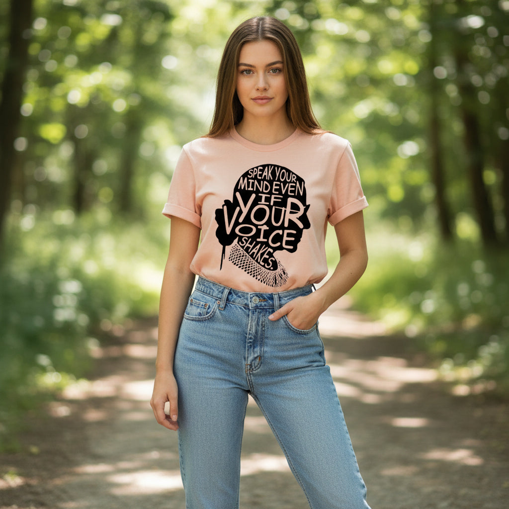 Pink t-shirt with motivational quote, white sneakers, and denim shorts on a wooden surface.